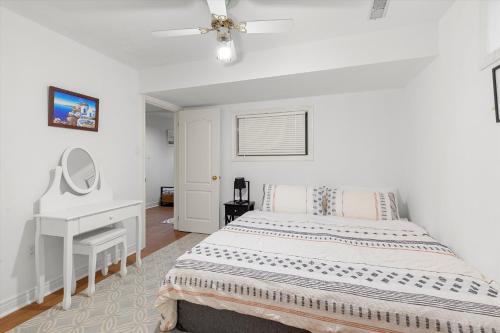 a white bedroom with a bed and a desk at Home Away From Home in Richmond Hill