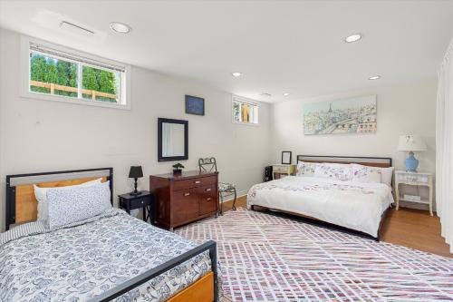 a bedroom with two beds and a dresser and two windows at Home Away From Home in Richmond Hill