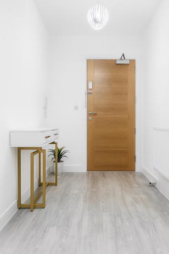 an empty room with a desk and a wooden door at Ebbsfleet Luxe in Swanscombe