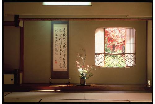 a room with a window and a vase with a plant at Iwaso in Miyajima