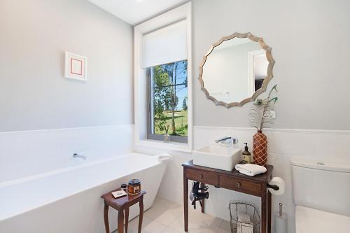 a bathroom with a tub and a sink and a mirror at Block Eight Estate Gum Trees Villa in Belford