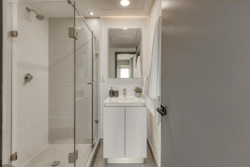 a white bathroom with a sink and a shower at Nido x Nomad Pablo Neruda GDL in Guadalajara