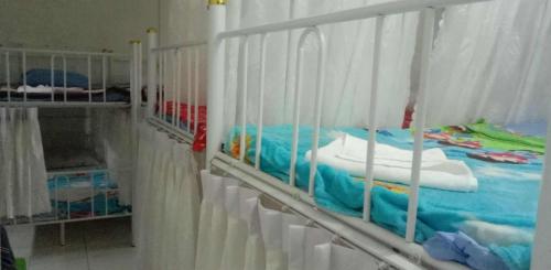 a bed in a room with white rails at Mekong Sedone Hostel Neva Paris in Pakse