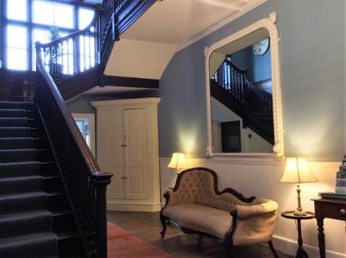 a living room with a chair and a mirror at Aberllynfi Riverside Guest House in Glasbury