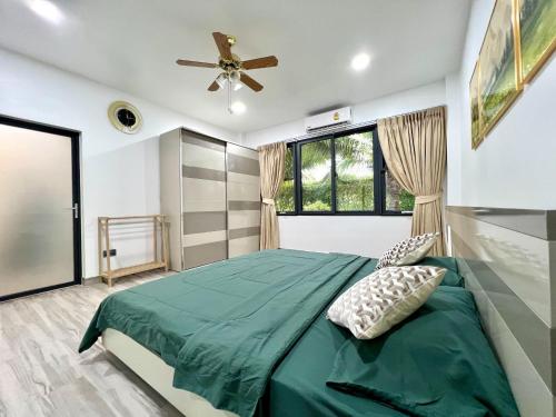 カオラックにあるKhaolak Alisa Houseのベッドルーム1室(緑色のベッド1台、天井ファン付)