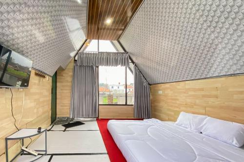 a bedroom with a large bed and a window at Merapi Hill Homestay Syariah Selo RedPartner in Selo