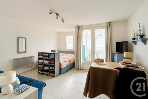 a bedroom with a bed and a table and a television at Waterfront apartment - Plage des Mouettes in Saint-Hilaire-de-Riez