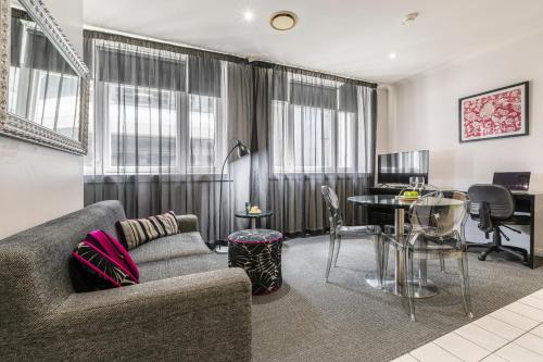 a living room with a couch and a table at Punthill Apartment Hotel - Flinders Lane in Melbourne