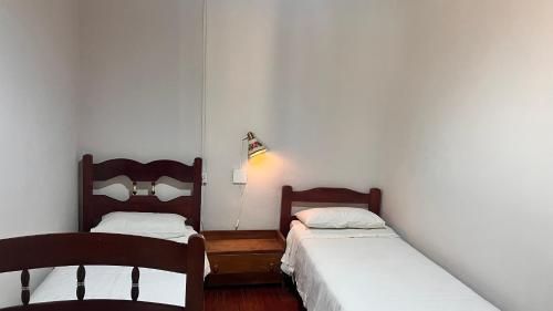 two beds in a room with white walls at Hostel da Dri in Aiuruoca