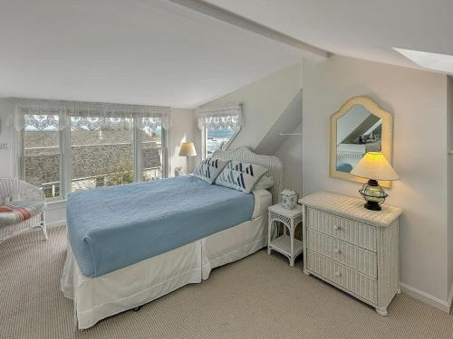 een slaapkamer met een blauw bed en een spiegel bij Perkins Cove Gem in Ogunquit