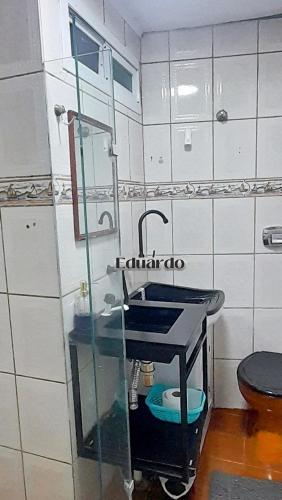 ein Badezimmer mit Waschbecken und Toilette in der Unterkunft Apartamento pé na areia no centro de Tramandaí! in Tramandaí
