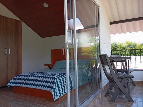 a bedroom with a bed and a glass wall at Hospedaje Rural La Fortaleza in San Miguel