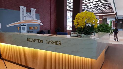 un mostrador de recepción en un edificio con flores en BCIC Lodge, en Kuantan