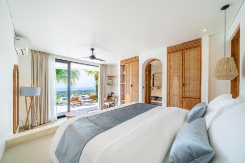 Ένα ή περισσότερα κρεβάτια σε δωμάτιο στο Bali Finest - 4BR Oceanview Luxury Villa with Rooftop pool and Cinema!