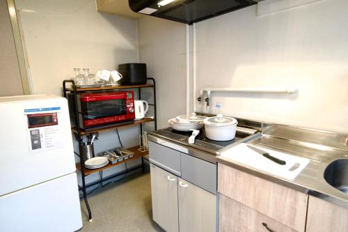 a small kitchen with a counter and a microwave at Guest House Re-worth Yabacho1 201 in Nagoya