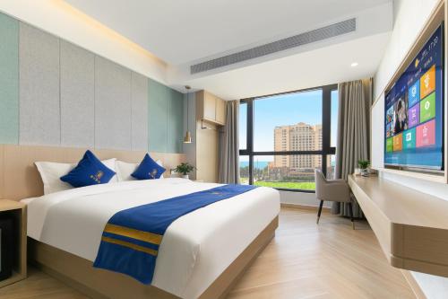 a hotel room with a large bed and a flat screen tv at Super 8 Selected Hotel Sanya Bay Coconut Dream Corridor in Sanya