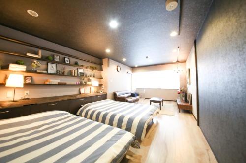 a hotel room with two beds and a couch at Guest House Re-worth Yabacho1 201 in Nagoya