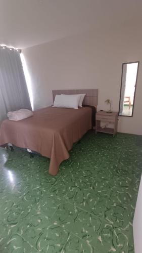 een slaapkamer met een bed met een groen tapijt bij Hotel villa 15 in Las Victorias