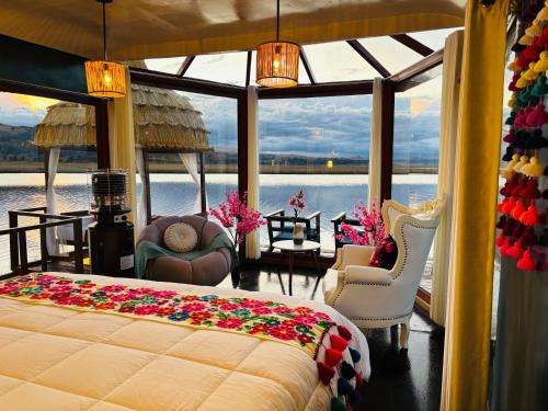 Un dormitorio con una cama y vista al agua. en Titicaca Maya Lodge Perú, en Puno
