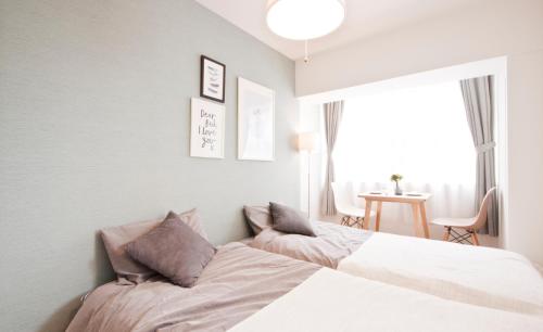 a bedroom with a bed and a window at Guest House Re-worth Yabacho1 301 in Nagoya