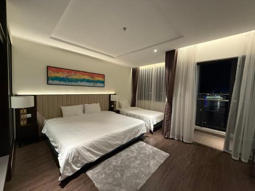 een hotelkamer met twee bedden en een raam bij Sky Homestay 1 in Ha Long