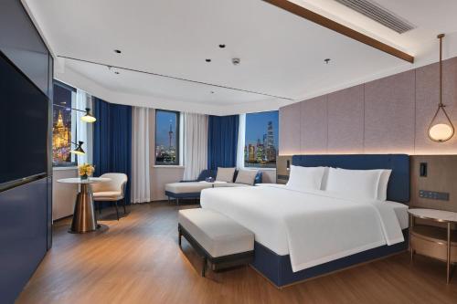 een slaapkamer met een groot wit bed en een woonkamer bij Jinglai Hotel Bushe - Shanghai Nanjing East Road Bund Branch in Shanghai
