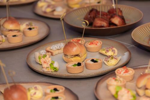 a table full of plates of food with sandwiches and pastries at SH Hotel in Phnom Penh