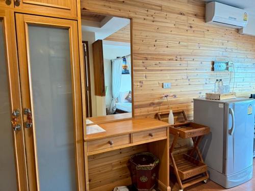 a bathroom with a sink and a mirror and a refrigerator at Maekhong Delta Boutique Hotel in Mae Sai