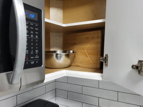 a kitchen with a sink and a microwave at Comfortable Two Bed Basement With Free WiFi, Laundry and Private Entry in Regina