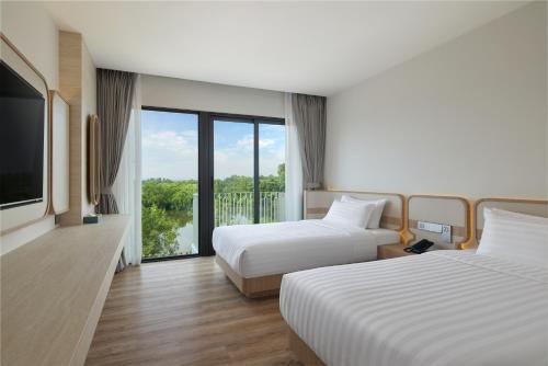 Ένα ή περισσότερα κρεβάτια σε δωμάτιο στο Phetara Hotel Mahachai by PCL