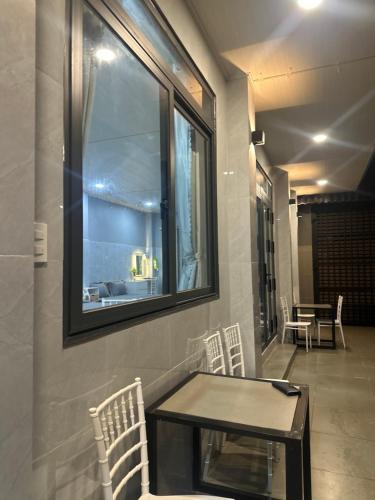 a table and chairs in a room with a window at Happy House Sài Gòn in Ho Chi Minh City