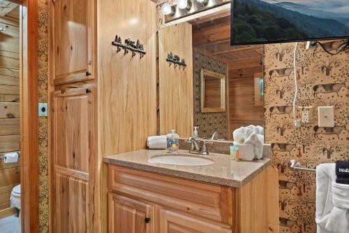 a bathroom with a sink in a wooden cabin at Cozy cabin, Bed swing, Arcade game, hot tub in Sevierville