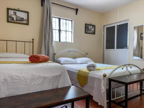 a bedroom with two beds and a table at Casa Dolores in Dolores Hidalgo