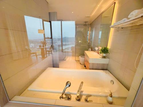 下龙湾À Là cart studio apartment with bay view and water music的带浴缸和水槽的浴室