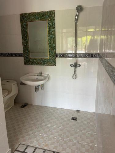 a bathroom with a sink and a shower and a toilet at Karmani Villa Managed by Alyssa Villa Management in Ujung