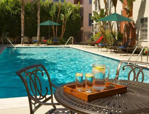a table with drinks on it next to a swimming pool at Premier Resort Style Living Minutes from Santa Monica in Los Angeles