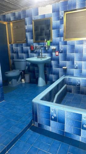 a blue tiled bathroom with a tub and a sink at Casa Vacacional Chula Vista in Acapulco