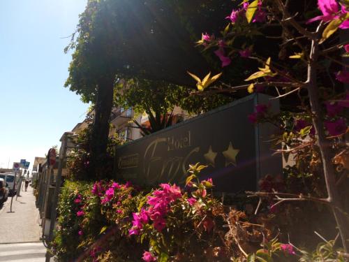 a sign for a hotel with flowers on a sidewalk at Hotel Eros in Lido di Camaiore