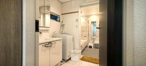 een kleine witte badkamer met een wastafel en een toilet bij KamakurakoshigoeekimaeA in Kamakura