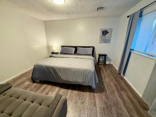 un dormitorio con una cama y un sofá en Charming Midwest 3 Bedrooms 2 Bathrooms, en Altus