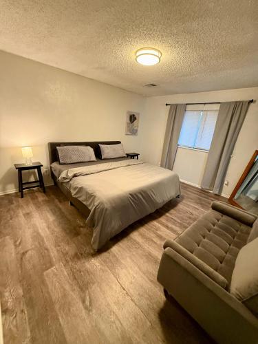 a bedroom with a large bed and a couch at Charming Midwest 3 Bedrooms 2 Bathrooms in Altus