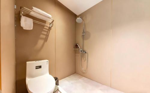 a bathroom with a toilet and a shower at Baiyuan Hotel Changgang Baogang Avenue Metro Station Branch in Guangzhou