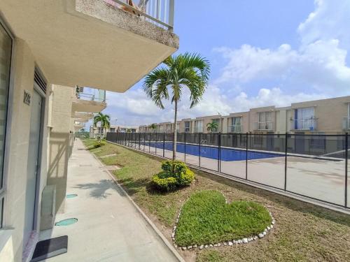 a balcony with a view of a pool and palm trees at Casa ubicada en zona campestre de Ibagué in Ibagué