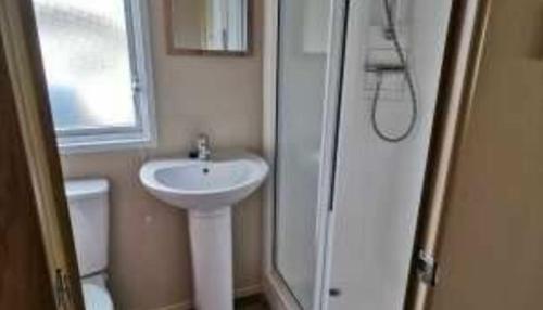a white bathroom with a sink and a shower at E67 DURDLE DOOR Ref 11663 in Wareham