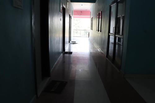 an empty hallway with a light shining through a door at OYO 86877 Hotel Bhuneshwar Inn in Rāmgarh