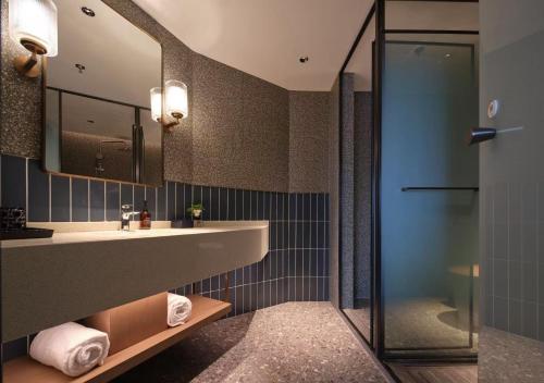 een badkamer met wastafel en douche bij Jinglai Hotel Bushe - Shanghai Nanjing East Road Bund Branch in Shanghai