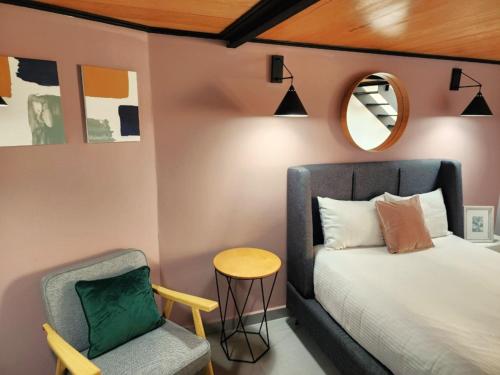 a bedroom with a bed and a chair and a mirror at NIU Modern Apartments near WTC & Condesa - Roma Sur in Mexico City