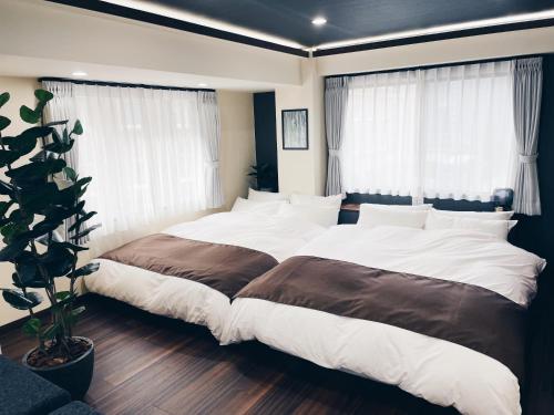 东京Plan A Tennozu Isle的卧室设有两张床,带两个窗户