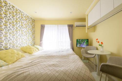 a bedroom with a bed and a window and a table at スカイフィール大久保 in Tokyo