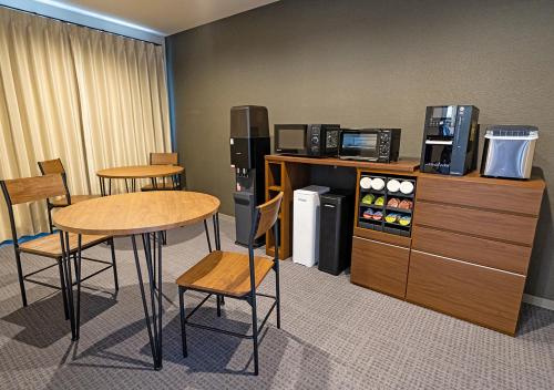 a room with a table and chairs and a refrigerator at Stay SAKURA Kyoto Station Shichijo in Kyoto